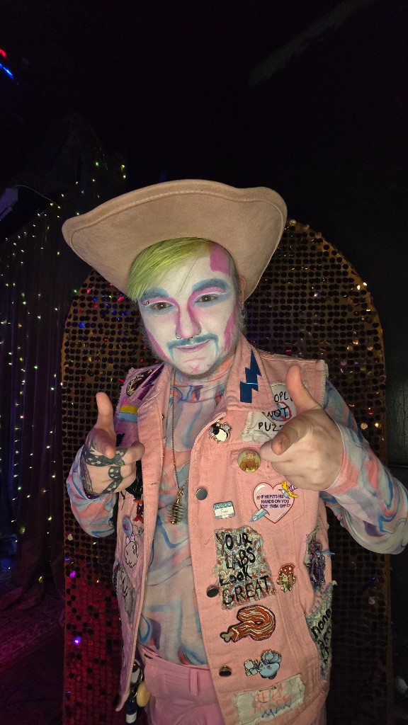 Quinnty Fre$h $exxx in a cowboy hat and patched vest, pointing finger guns at the camera